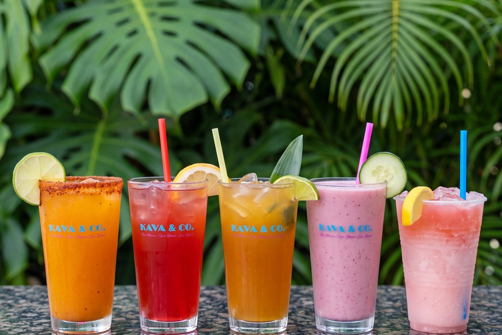 Row of colorful Kava & Company mocktails with fresh fruit garnish